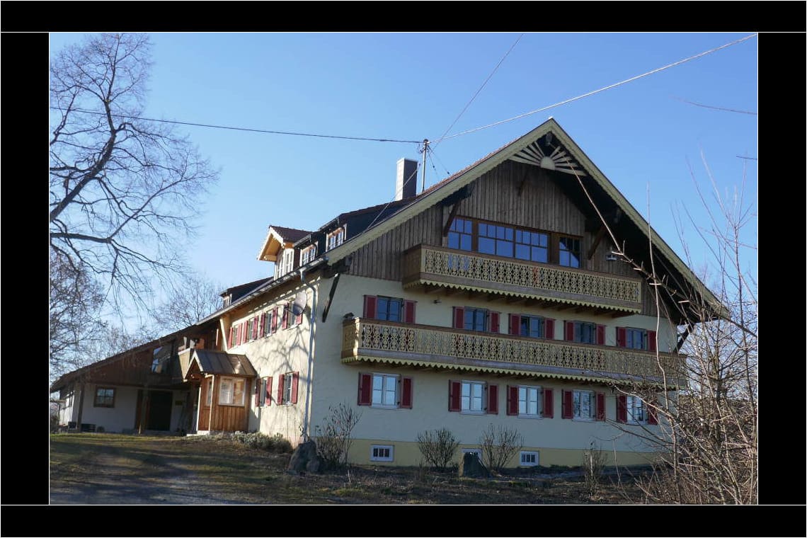 Heute ist die Front der Hirschau 2 mit gelben Balkonen ausgestattet, die Fassade in gelb gestrichen. Den Giebel ziert eine hölzerne Sonne. © Tanja Saß Hirschau im Frühling