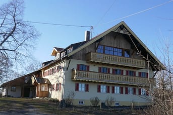 Heute ist die Front der Hirschau 2 mit gelben Balkonen ausgestattet, die Fassade in gelb gestrichen. Den Giebel ziert eine hölzerne Sonne. © Tanja Saß Hirschau im Frühling